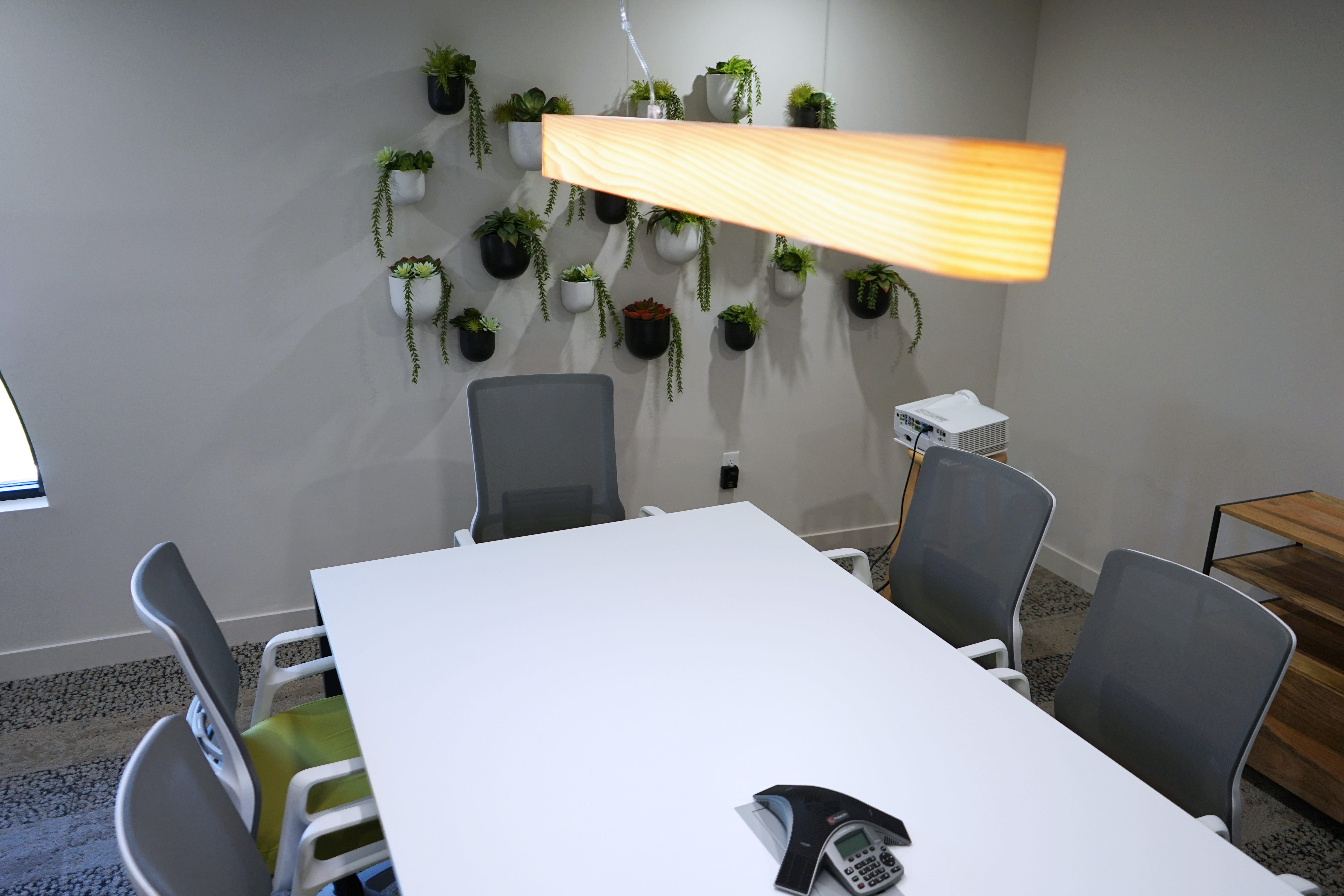 A calm, plant-filled 9 to 5 Office conference room — the space behind the systems.