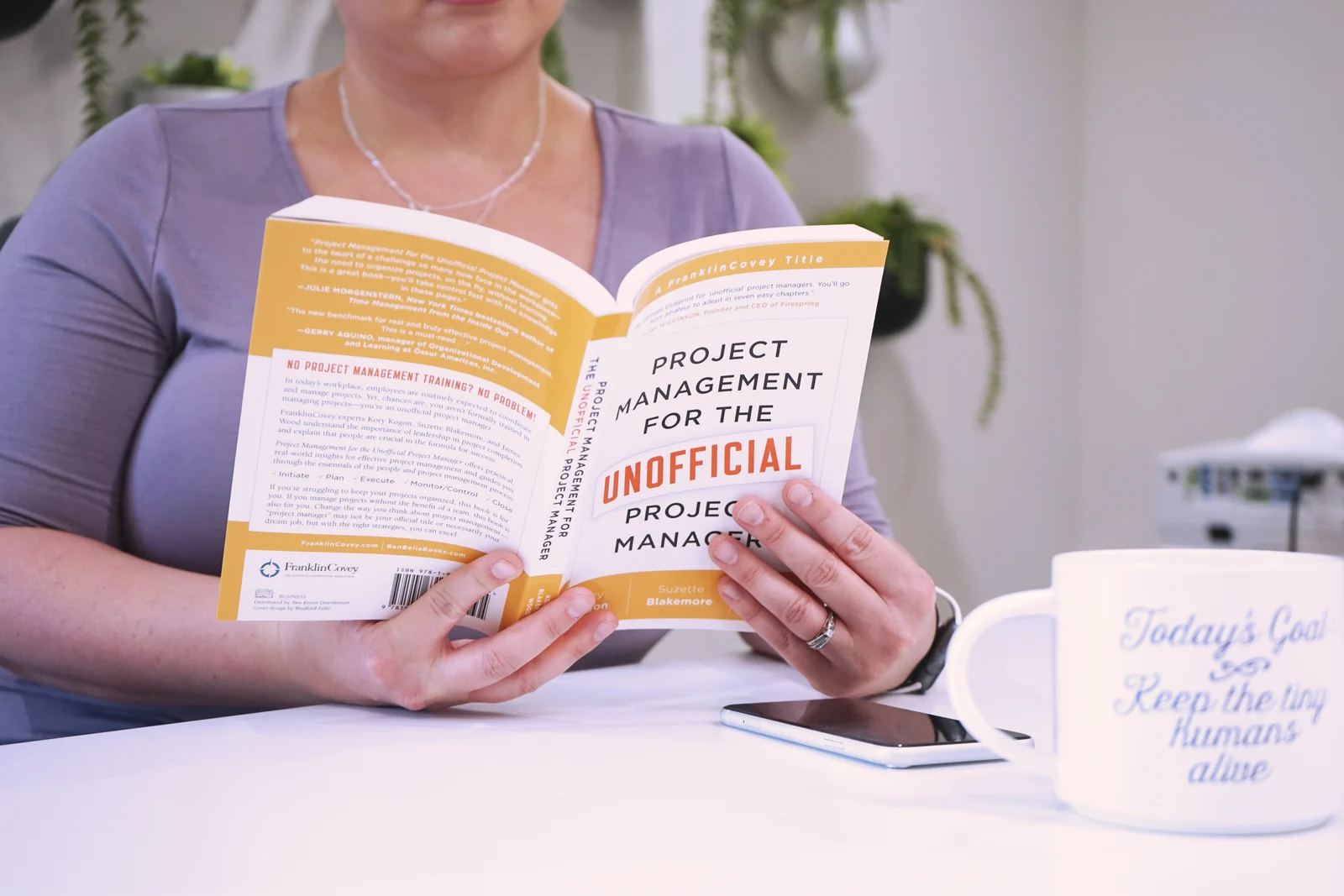 A 9 to 5 Office team member reading Project Management for the Unofficial Project Manager.